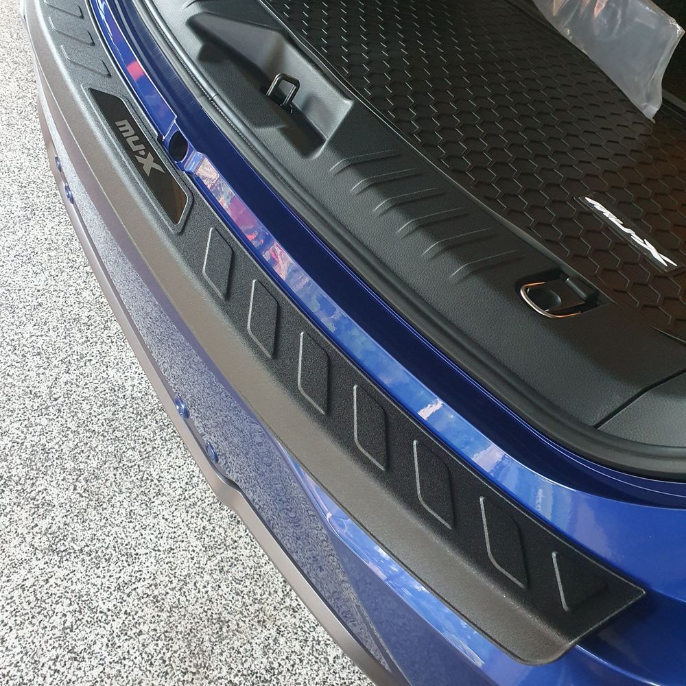 Matte black boot scuff plate cover fitted on the rear bumper of a blue Isuzu Mu-X vehicle.
